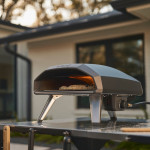 Profil latéral détaillé du Ooni Koda 2 montrant pizza en cuisson, brûleur à flamme active, contrôle 
